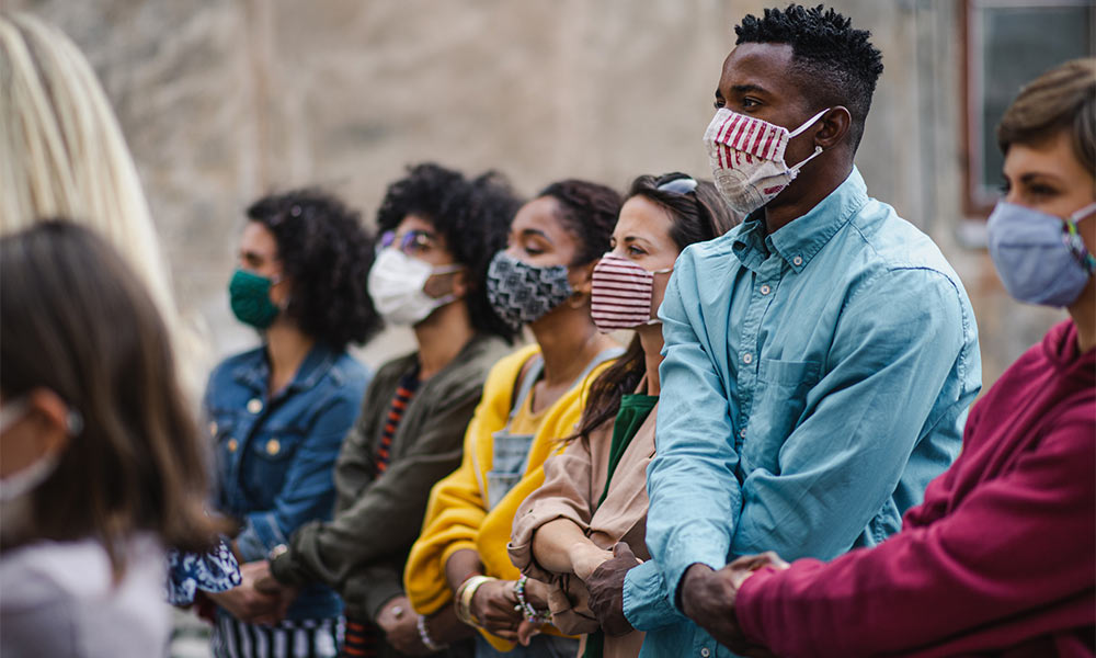 group holding hands in masks